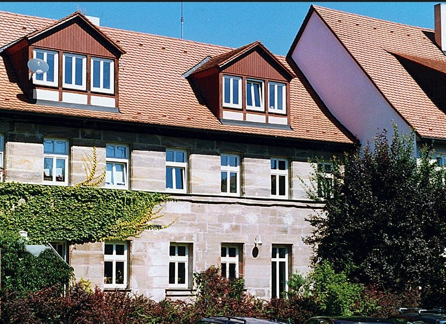 Sanierte Stadthäuser aus Sandstein mit Efeu und Gauben
